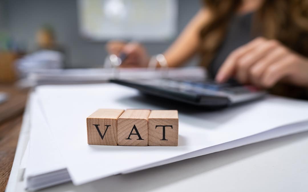 Businessperson`s Hand Calculating VAT With Calculator